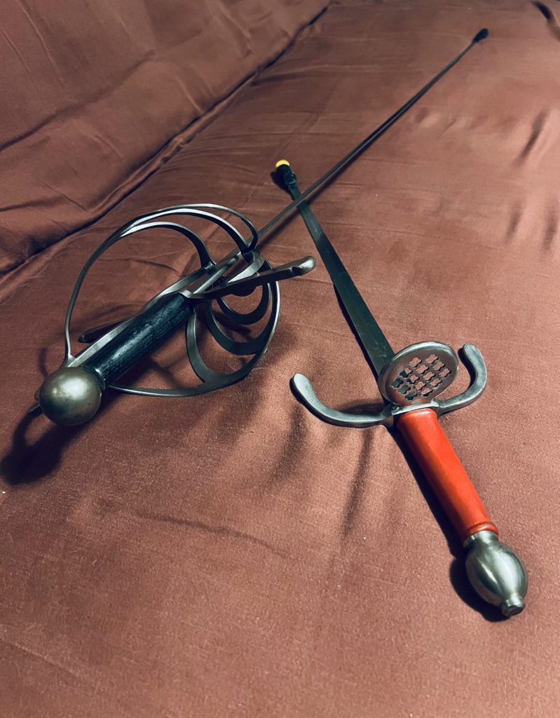 A sword with a black hilt and a dagger with a red hilt